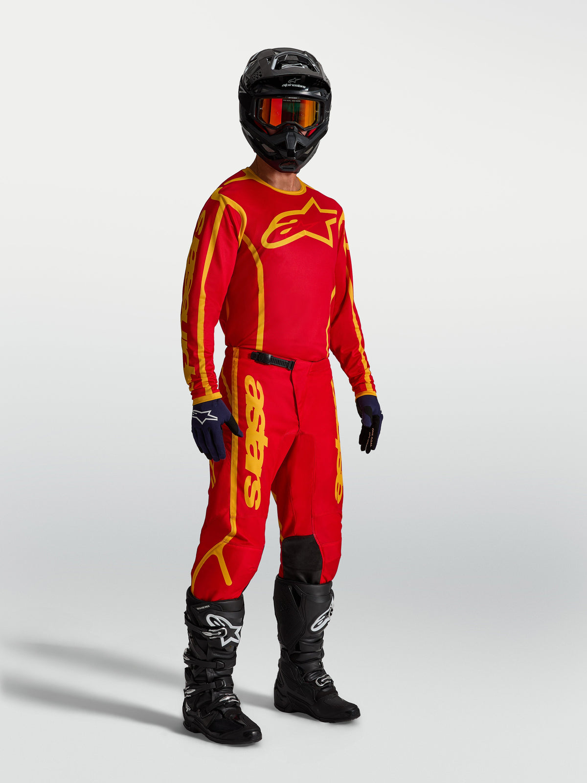 Alpinestars Fluid Apex V2 Trikot, Motocross-Trikot für Herren, Rot und Gold, aus atmungsaktivem feuchtigkeitsableitendem Polygewebe, am Model gezeigt.