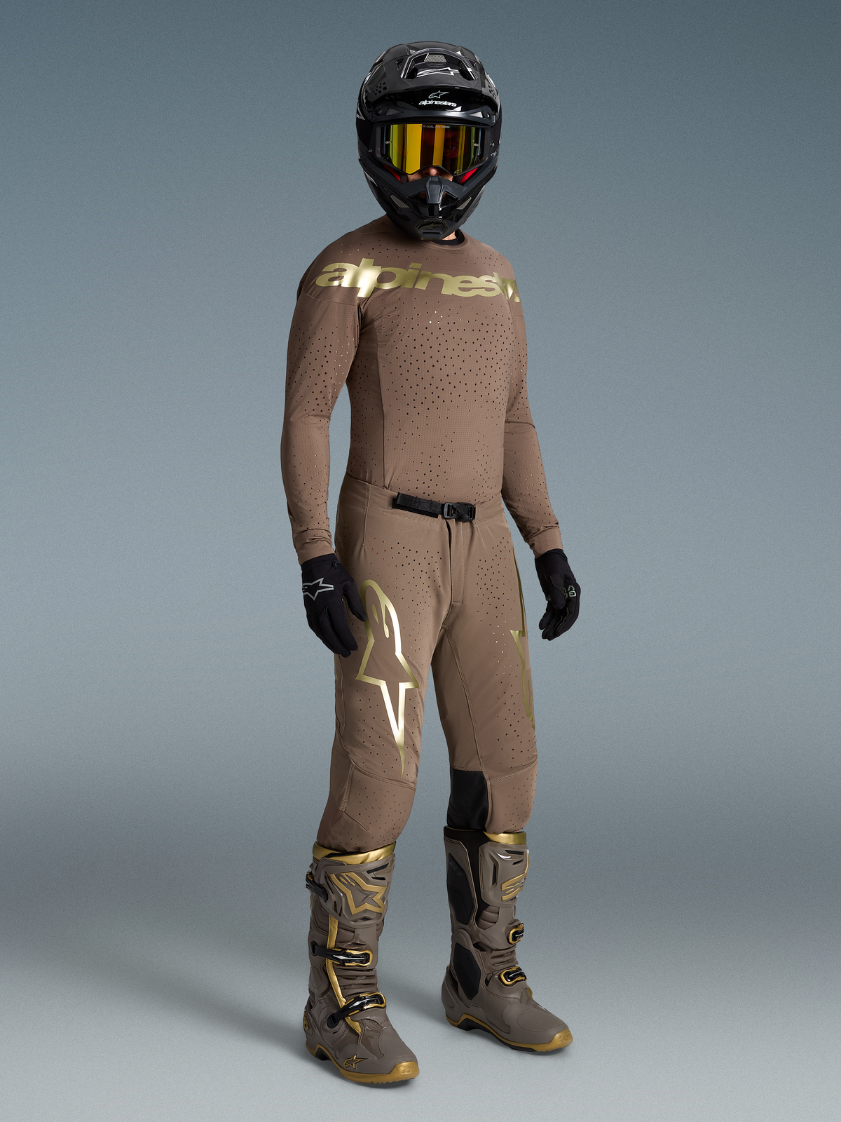 Alpinestars Supertech Air Gold Motocross Gear Set, Men's ventilated brown and gold jersey, pants, and boots with black helmet.