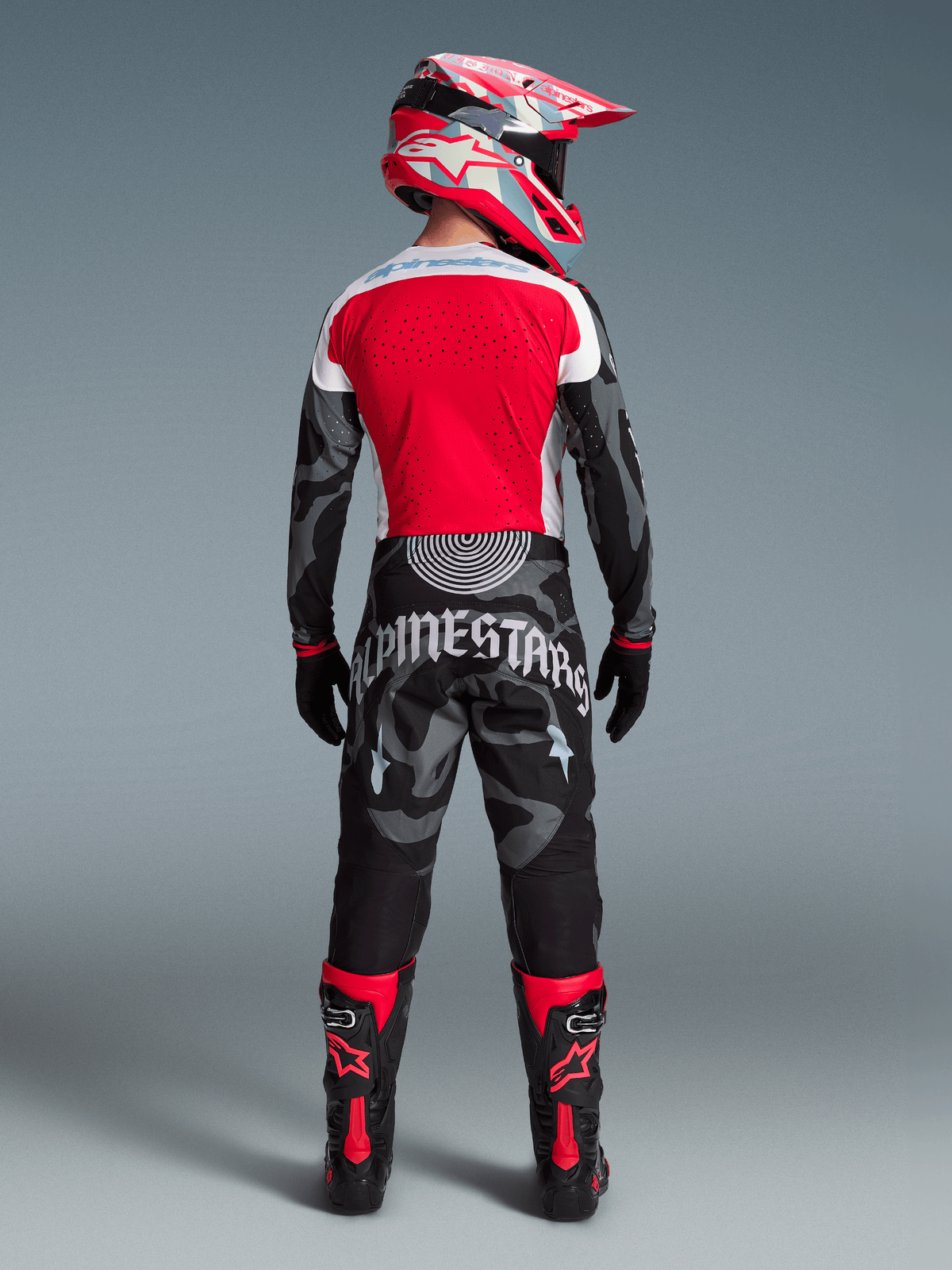 Alpinestars Techstar Beast Coast MX-Ausrüstung, rotes Trikot und Camo-Hose mit passendem Helm und Stiefeln von hinten.