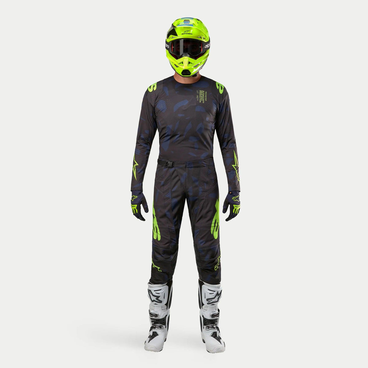 Motocross-Fahrer in kompletter Rennausrüstung, 2024 Techstar Rantera Jersey in Schwarz, Navy und Gelb Fluo, passende Hose mit abstraktem Muster, leuchtend fluo-gelber Helm, weiß-schwarze Stiefel, abgestimmtes Outfit für den Offroad-Rennsport