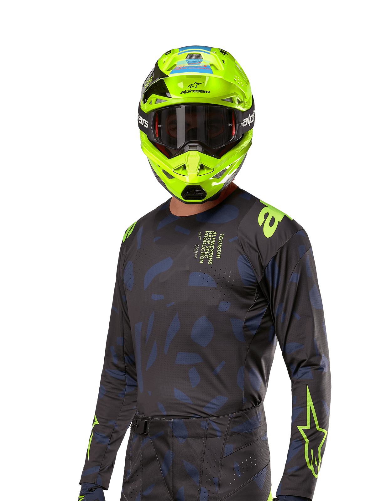 Alpinestars 2024 Techstar Rantera Trikot, Motocross-Renntrikot, Schwarz und Marineblau mit abstrakten Mustern und neongelben Akzenten, getragen mit passendem neongelbem Helm, Performance-Passform für Offroad-Fahrten