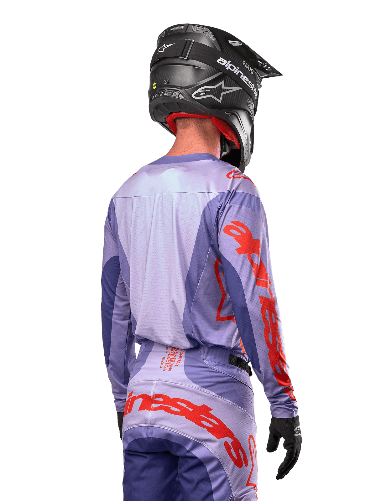 Alpinestars 2024 Techstar Ocuri Jersey, Motocross-Trikot, Lila und Hot Orange, Rückansicht eines Fahrers in passender Ausrüstung und schwarzem Helm, mit großem orangefarbenem Alpinestars-Schriftzug auf den Ärmeln und dem unteren Rücken