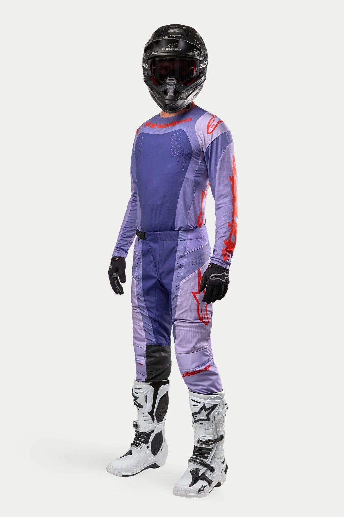 Motocross-Fahrer im Alpinestars 2024 Techstar Ocuri Trikot in Purple Hot Orange, passender lila Rennhose mit orangefarbenen Akzenten, schwarzem Helm, weiß-schwarzen Stiefeln und schwarzen Handschuhen, komplette Offroad-Wettkampfausrüstung
