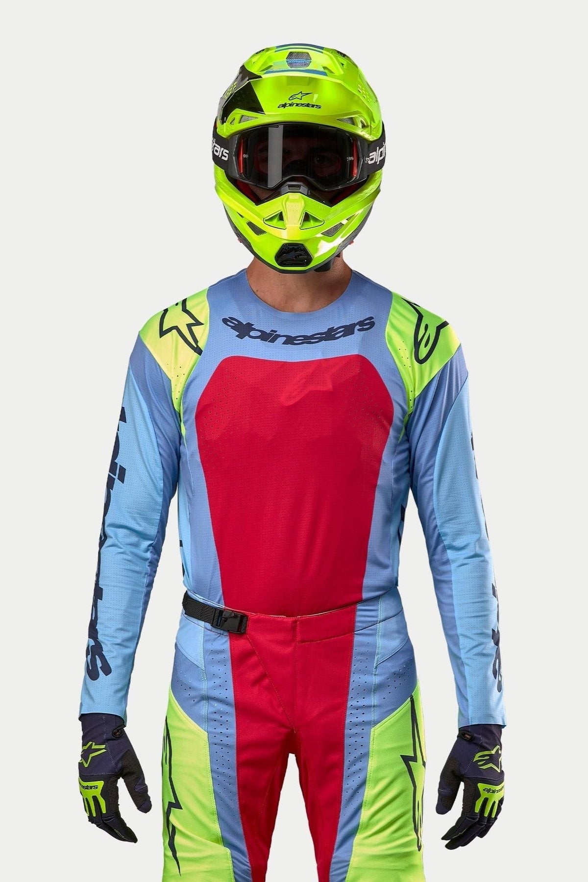 Motocross-Fahrer in kompletter Rennausrüstung, 2024 Techstar Ocuri Trikot in Hellblau mit einem großen Red Berry Brustpanel und gelben Fluo-Schulterakzenten, passender fluoreszierend gelber Helm, koordinierte rote und gelbe Fluo-Hose, professionelles Outfit für den Offroad-Rennsport