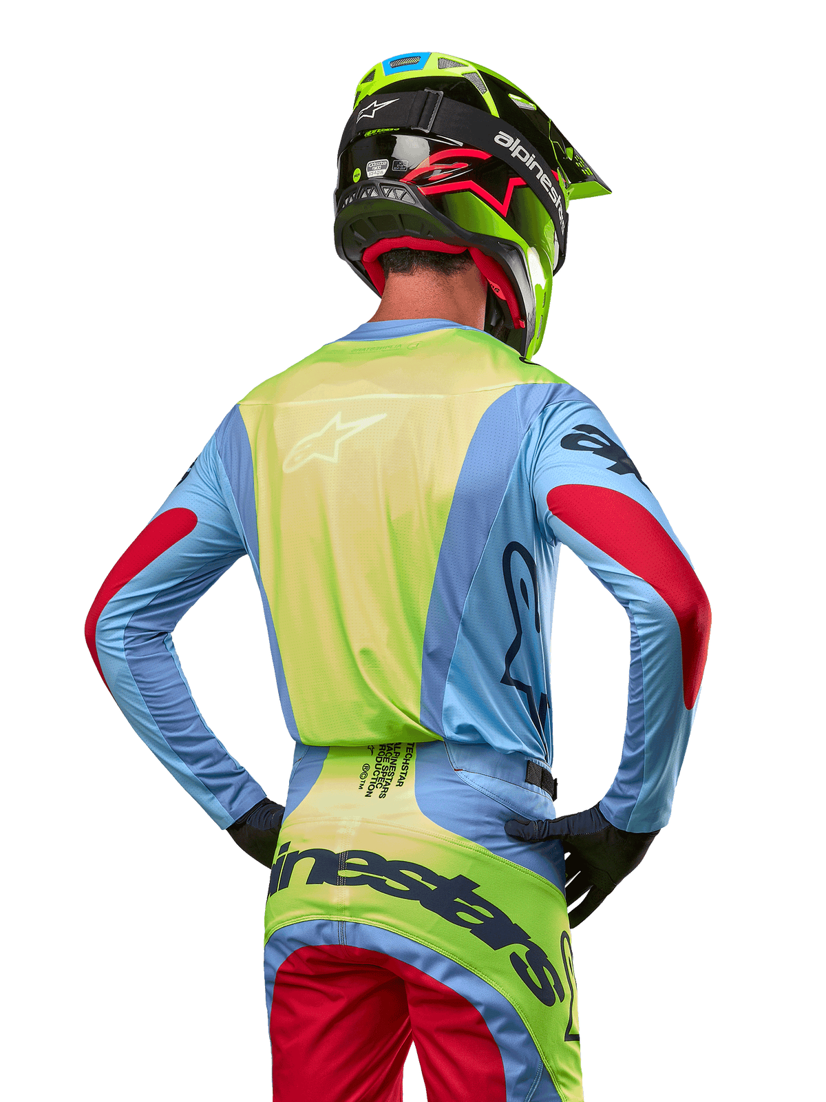 Motocross-Fahrer von hinten im Alpinestars 2024 Techstar Ocuri Trikot, Hellblau mit neongelber Rückseite und roten Ärmelakzenten, passende Motocross-Hose und neongelber Helm, abgestimmtes Outfit für Offroad-Rennen