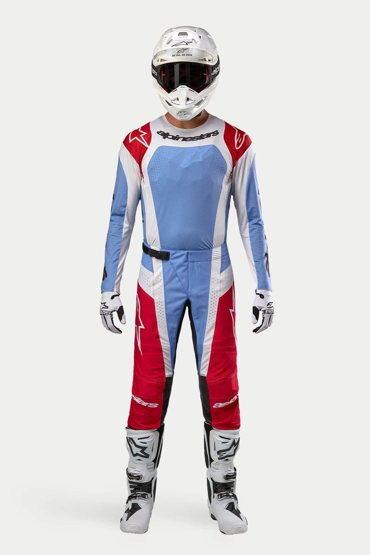 Motocross-Fahrer mit 2024 Techstar Ocuri Trikot in Hellblau, Mars-Rot und Weiß, passende Motocross-Hose, weißer Helm mit Brille und weiße Stiefel, komplette professionelle Offroad-Rennausrüstung
