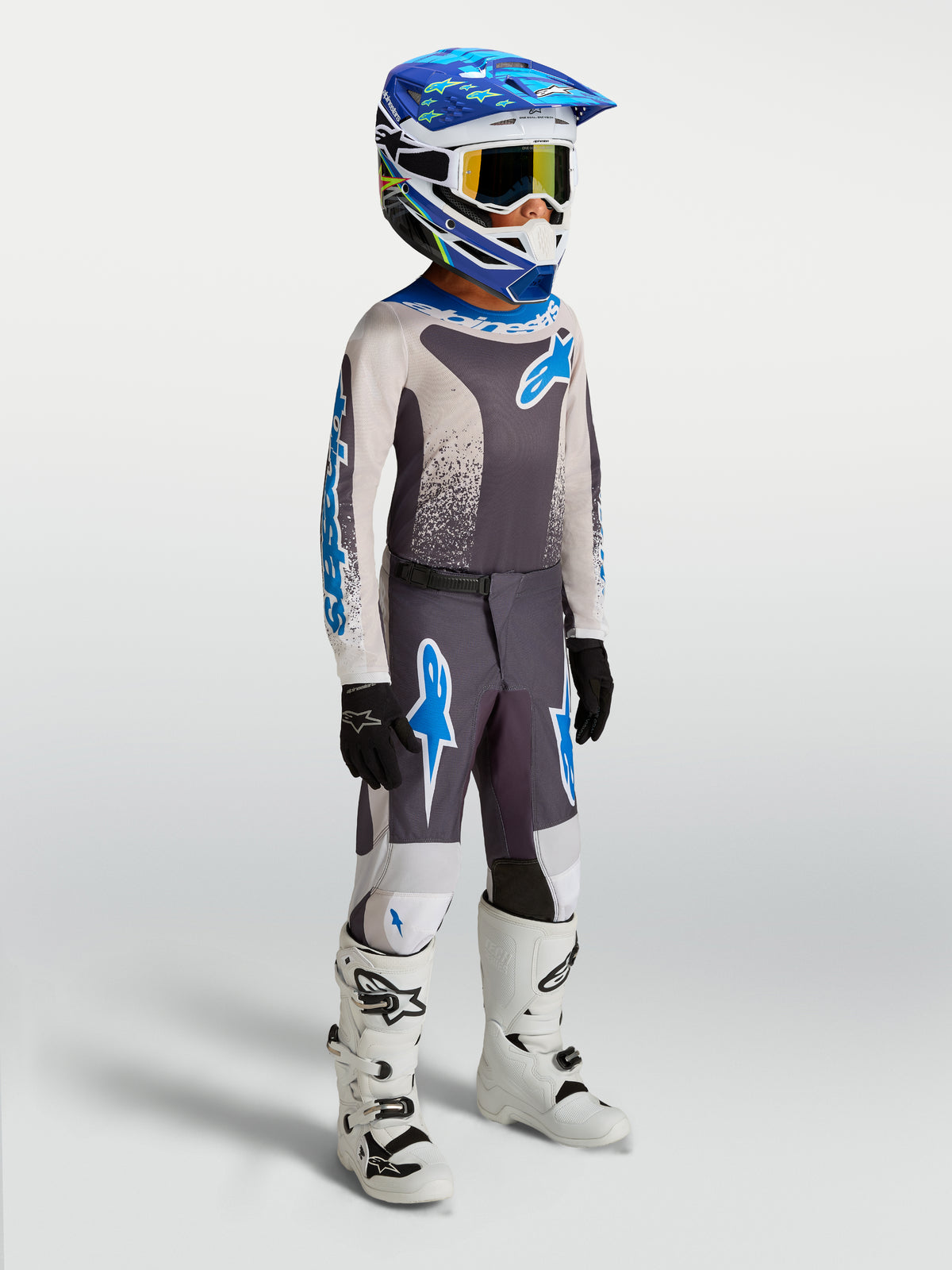 Alpinestars Fluid Jugend-Trikot Drag 2027 und Gear Set, Motocross-Ausrüstung in Grau und Blau mit weißen Stiefeln.