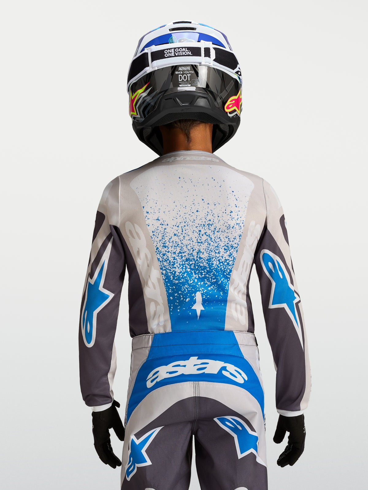 Alpinestars Fluid Jugend-Trikot Drag, Motocross-Renntrikot, Grau und Blau, atmungsaktive Konstruktion, Rückansicht mit Helm