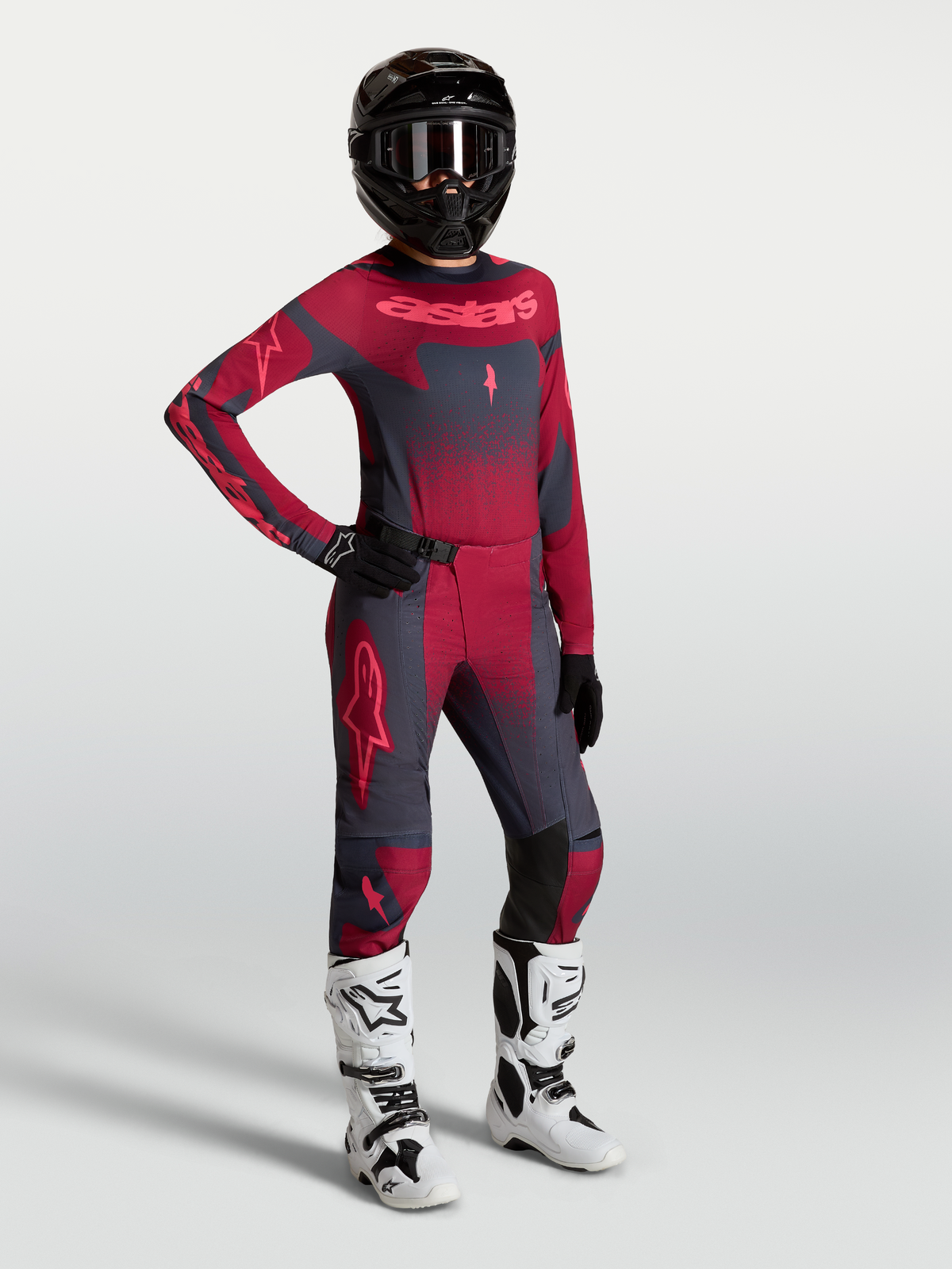 Alpinestars Stella Techstar Swan Hose und Trikot, Damen-Motocross-Outfit in Dunkelrot und Dunkelgrau mit weißen Rennstiefeln.