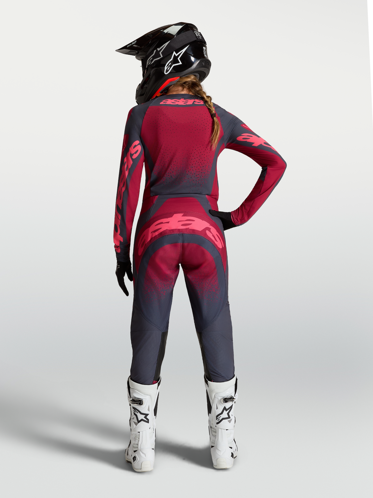 Alpinestars Stella Techstar Trikot Swan, Damen-Motocross-Trikot in Rot und Dunkelgrau, Rückansicht am Model mit Ausrüstung.