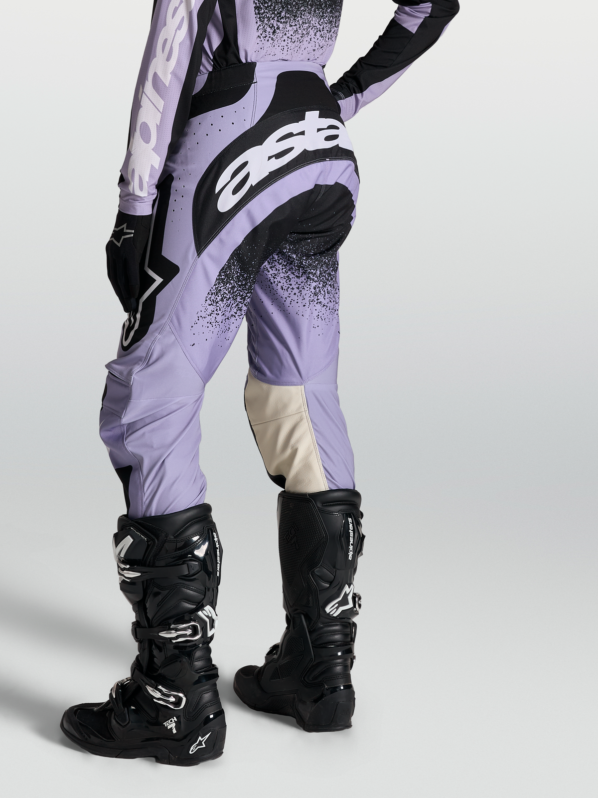 Alpinestars Stella Techstar Hose Swan, Damen-Motocross-Hose in Violett und Schwarz, kombiniert mit schwarzen Tech 7 Stiefeln.