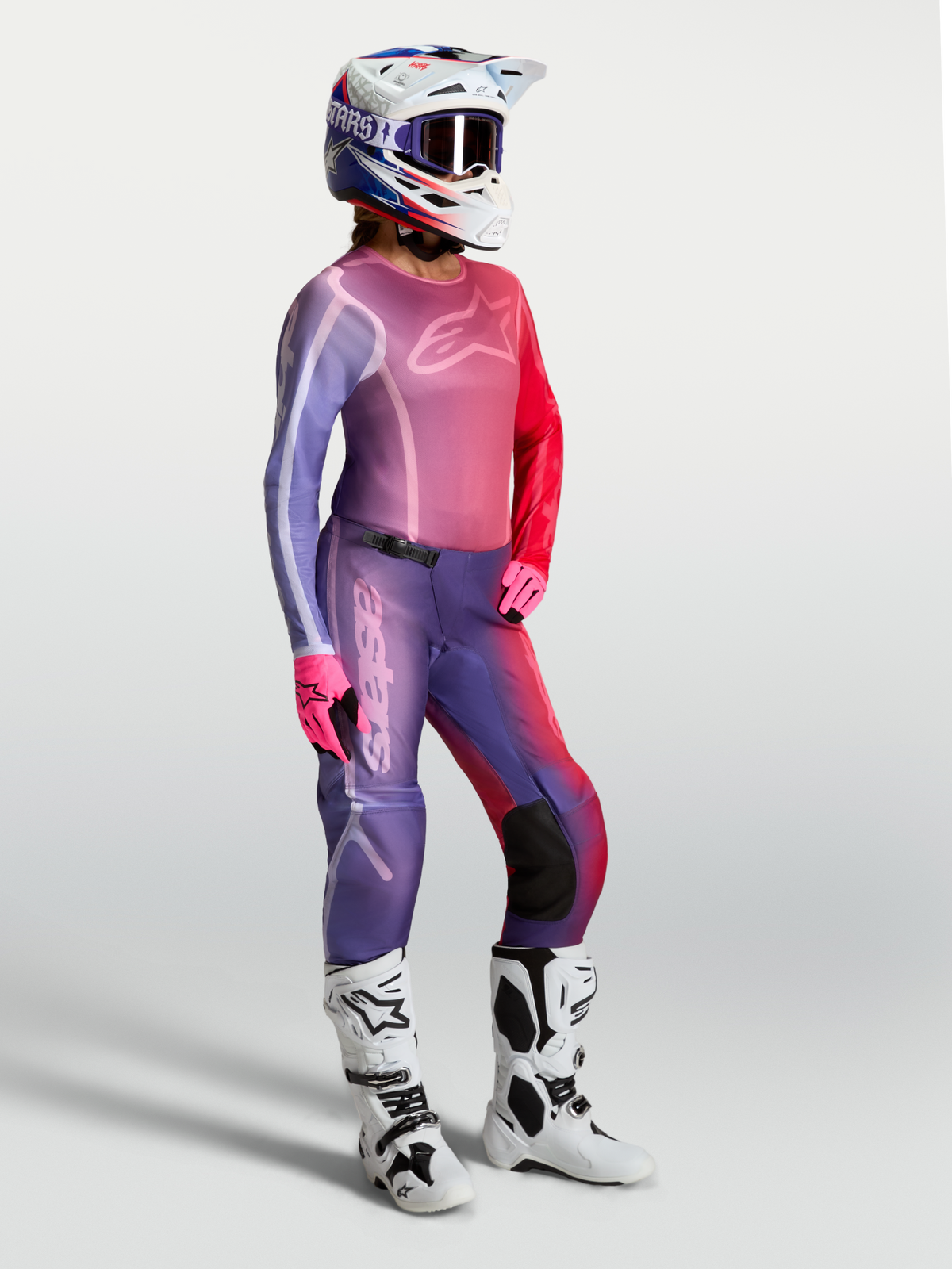 Alpinestars Stella Fluid Kepler Damen-Motocross-Trikot in Lila und Rot, mit passender Hose und weißen Stiefeln.