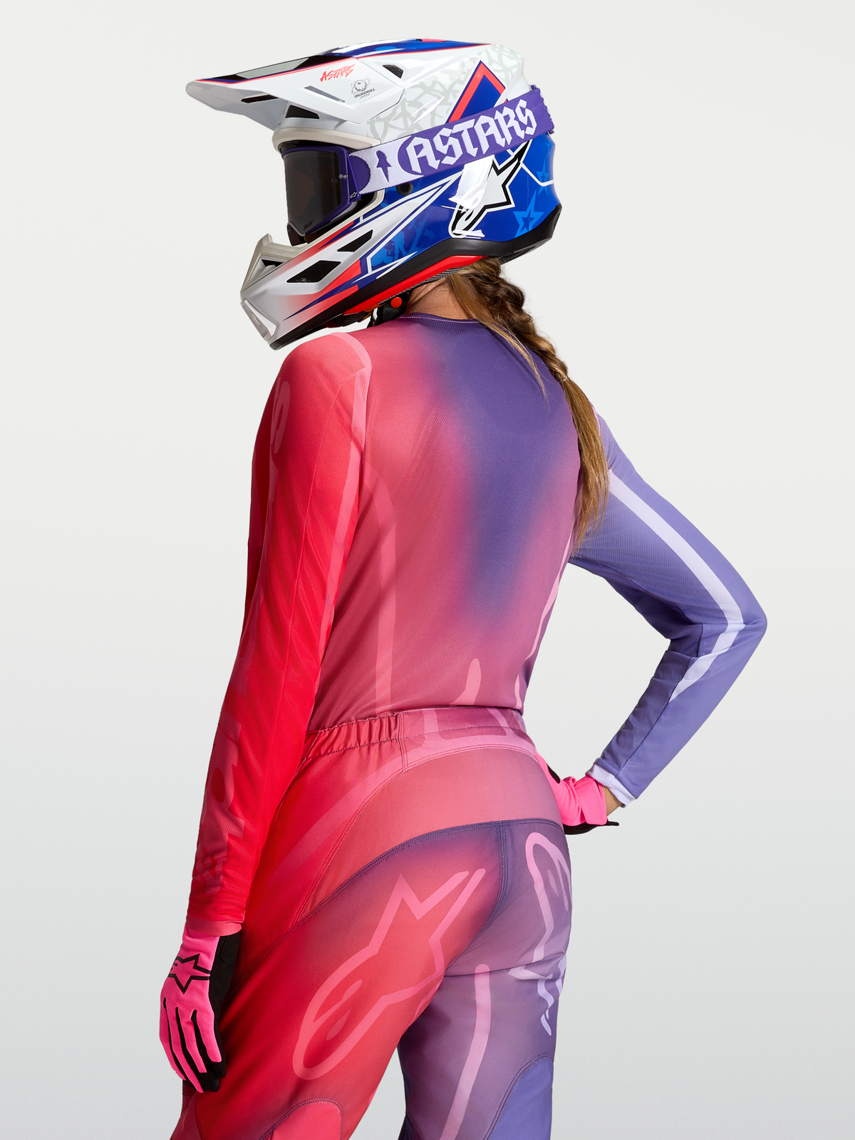 Alpinestars Stella Fluid Kepler Trikot, Damen-Motocross-Ausrüstung, Lila und Rot, Farbverlauf, getragen mit passender Hose und Helm, offroad-taugliches Polygewebe mit verlängertem Rückenteil.