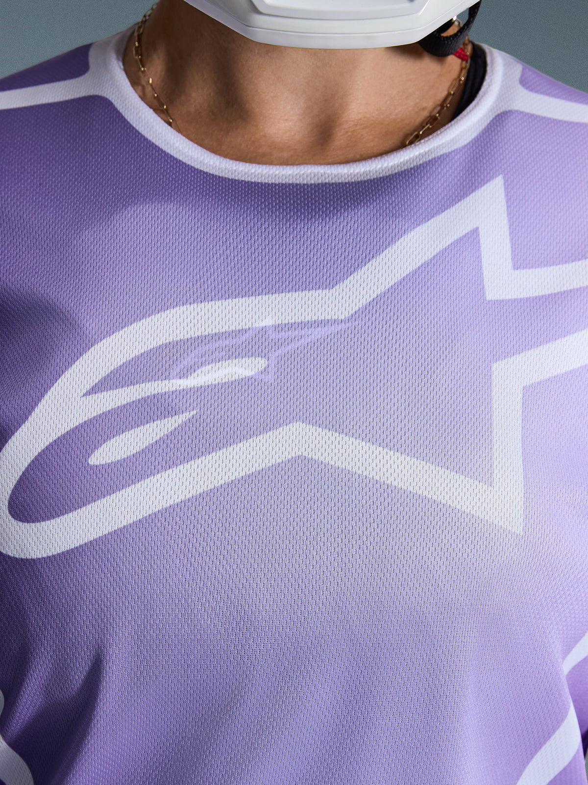 Alpinestars 2026 Stella Fluid Apex Trikot, Nahaufnahme der Brust, Lila mit weißen Grafiken, großes weißes Astars-Logo auf Mesh-Polygewebe-Konstruktion.