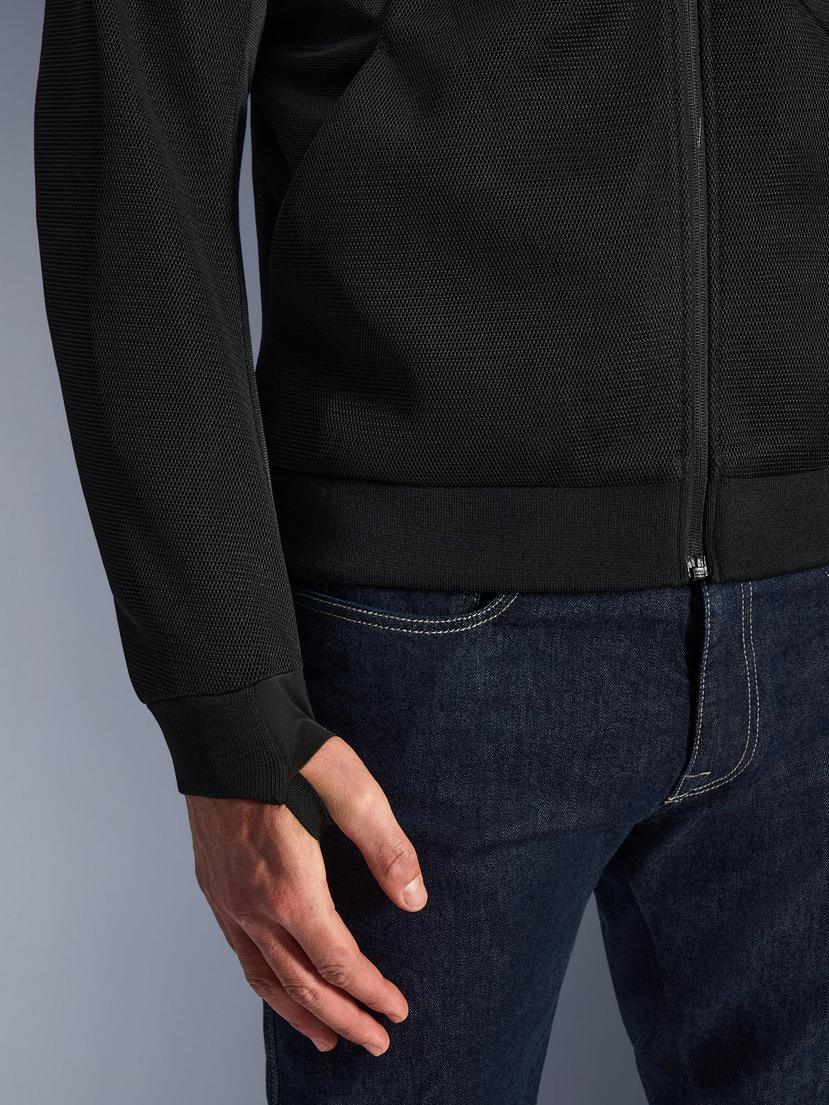 Alpinestars Chrome Superairflow Hoodie, Black, close-up of high-resistance 3D technical mesh fabric, featuring ribbed stretch jersey cuff with elastic retention thumb loop, worn with blue jeans