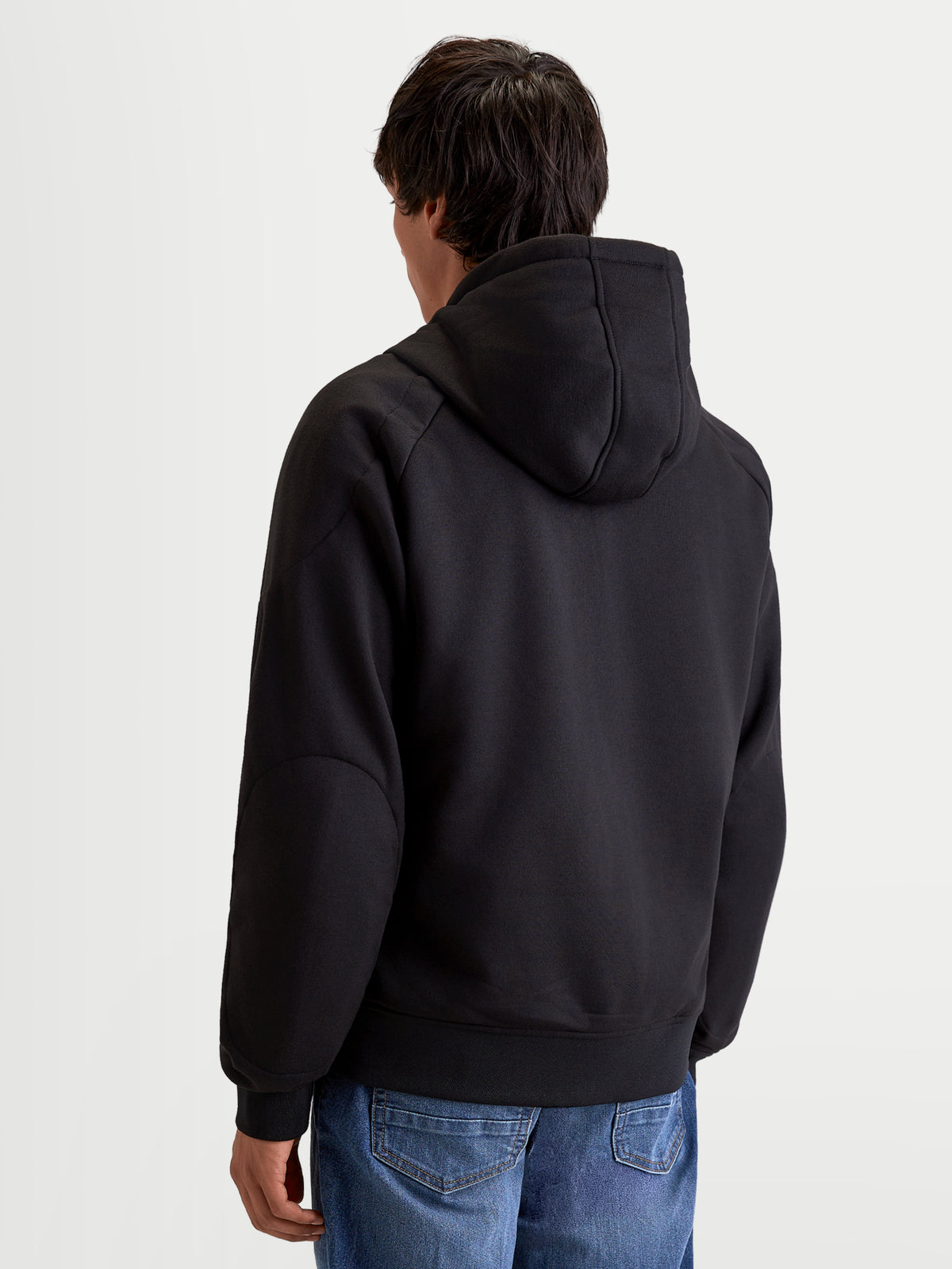Alpinestars Ageless Kapuzenpullover, urbaner Motorrad-Kapuzenpullover für Herren in Schwarz, Rückansicht an einem Model mit fester Kapuze und legerer Textilkonstruktion