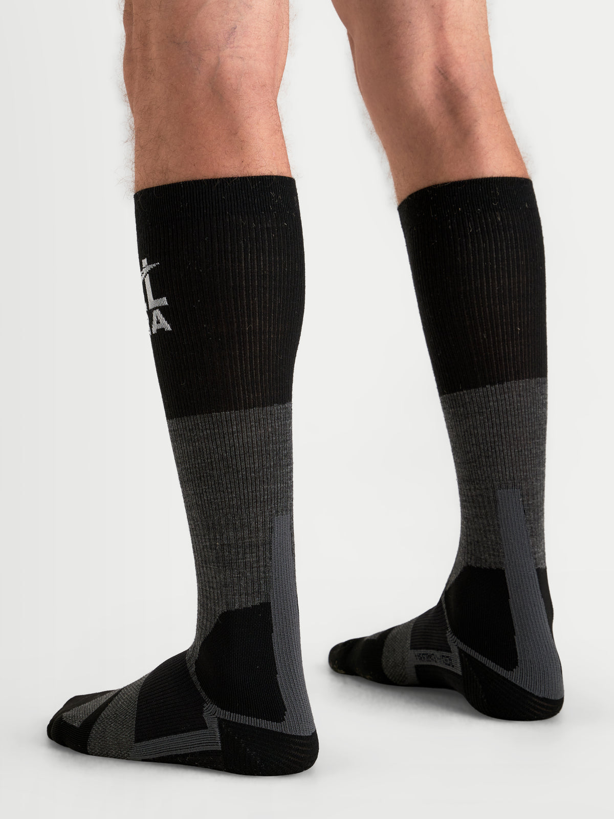 Alpinestars At 8 Merino Socken, Adventure-Motorradsocken in Teergrau und Schwarz, kniehohe Thermoschutzbekleidung mit verstärkter Polsterung, getragen von einem Model