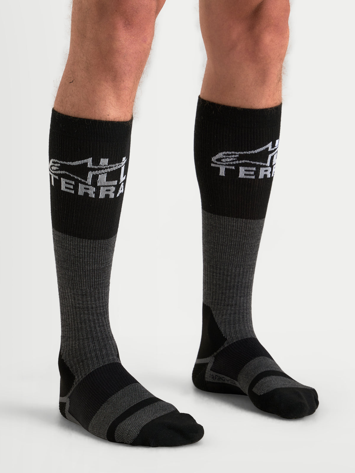 Alpinestars AT-8 Merino Socken, Adventure-Motorradsocken, Teergrau und Schwarz, mit Merinowollmischung und All-Terra-Branding, getragen von einem Model