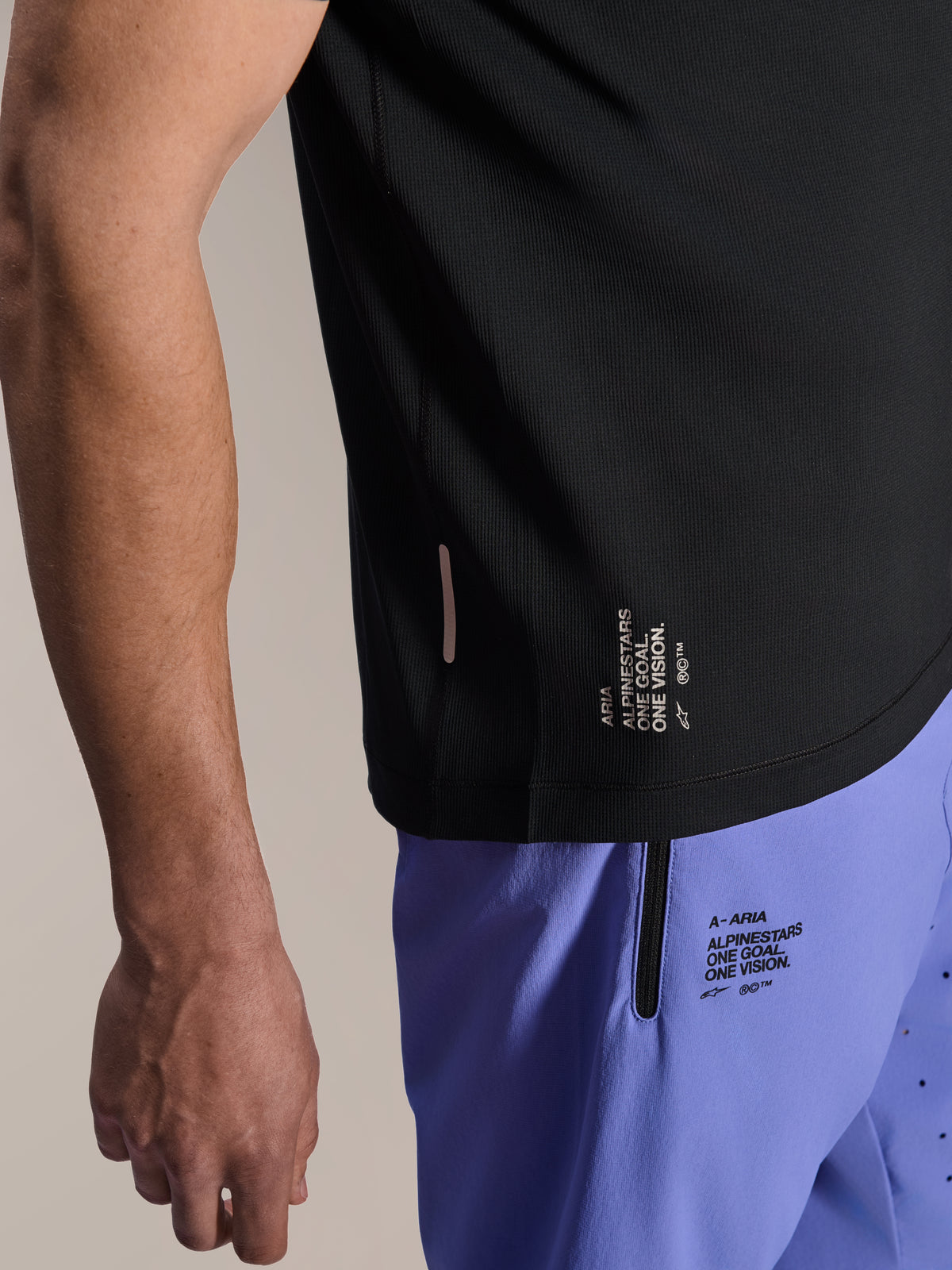 Alpinestars A-Aria Lite Short in Baja Blue, MTB Shorts, featuring screen-printed 'One Goal. One Vision.' branding and zippered pocket, paired with a black A-Aria Switch jersey, close-up view of technical cycling gear.
