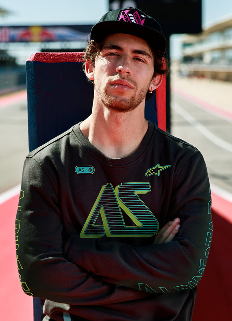 Alpinestars Ayess Csf Tee, Langarm-T-Shirt, Schwarz, mit grün-gelben AS-Grafiken mit Farbverlauf auf Brust und Ärmeln, lässige, vom Motorsport inspirierte Streetwear, getragen auf einer Rennstrecke