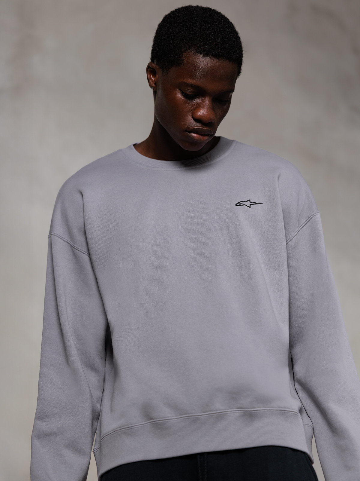 Alpinestars Essentials Ageless Crew, Silver premium crewneck sweatshirt, featuring a small black Alpinestars logo on the chest, worn by a model, casual lifestyle streetwear with a soft fleece texture.
