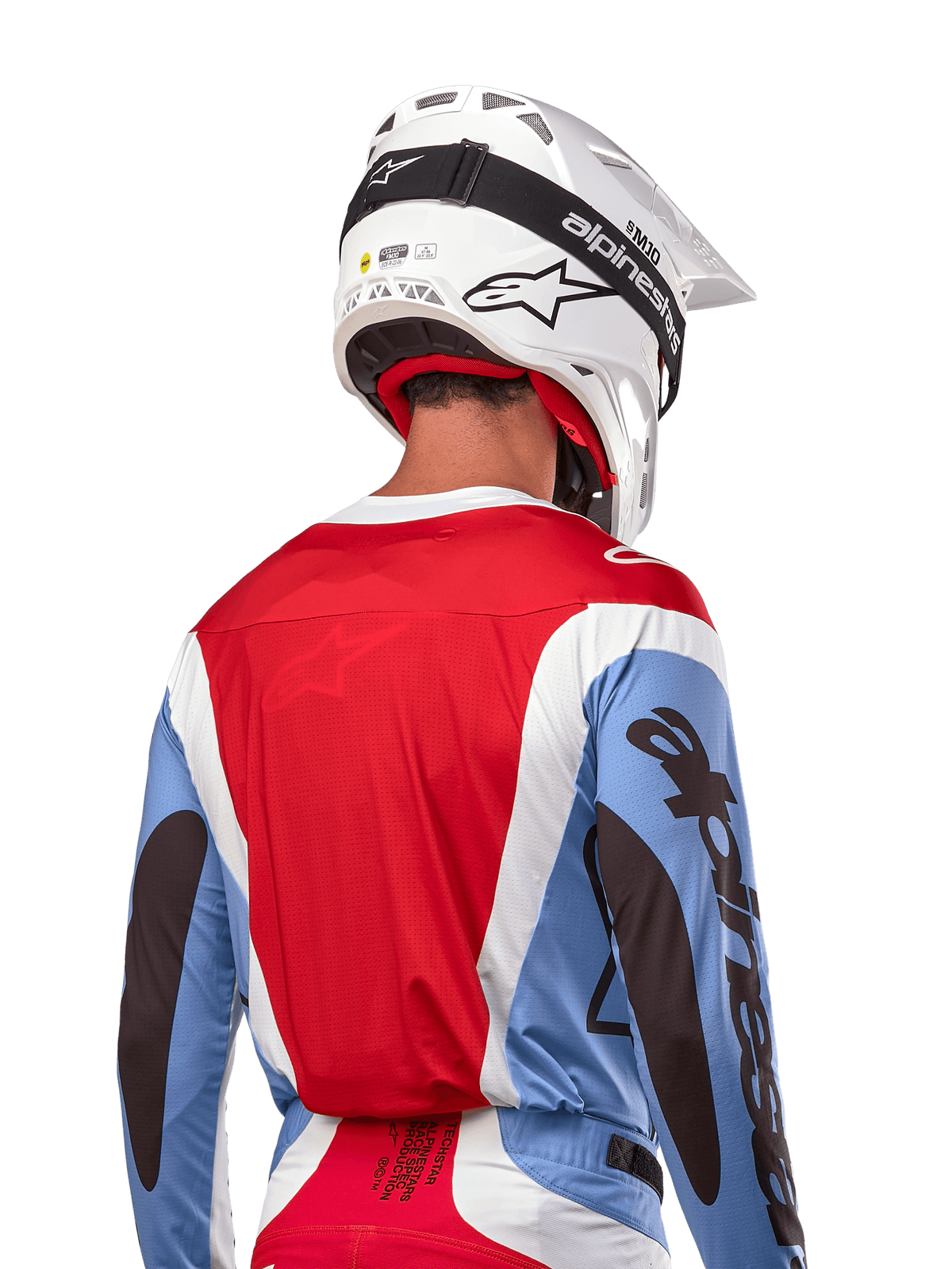 Alpinestars 2024 Techstar Ocuri Trikot, Motocross-Trikot, Hellblau, Marsrot und Weiß, Rückansicht eines Fahrers mit passendem weißem Helm und schwarzer Schutzbrille, markantes schwarzes Branding an den Ärmeln und ergonomische Race-Passform für Offroad-Performance