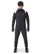 Alpinestars A-Dura Regenjacke, Mountainbike-Regenjacke, Schwarz mit weißen Schulterakzenten und weißem Logo auf der Brust, getragen mit schwarzer Hose, schwarzem Helm, Sonnenbrille und Handschuhen, abgestimmte Mountainbike-Ausrüstung für nasses Wetter