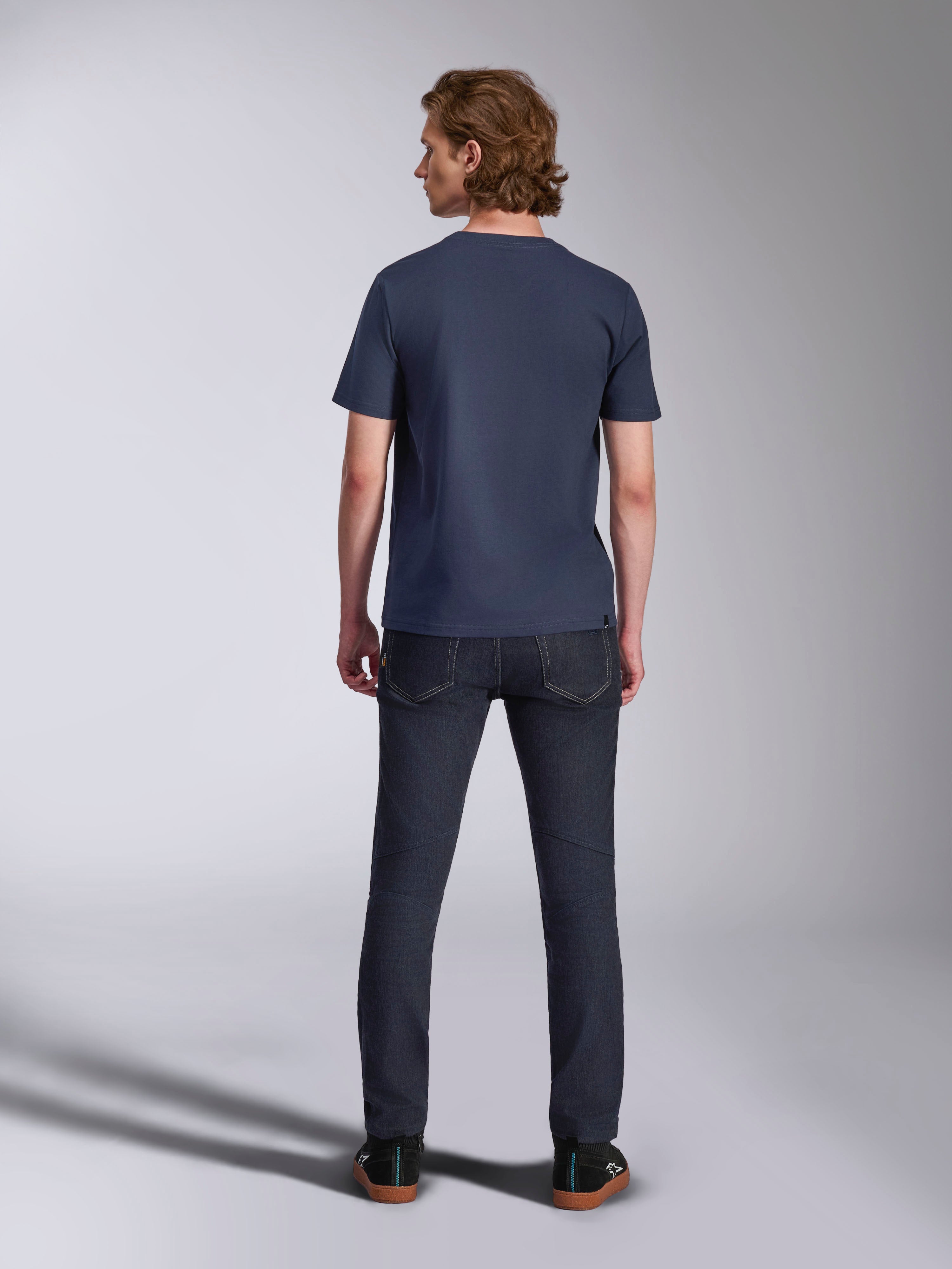 Alpinestars Ageless 2.0 CSF T-Shirt, Kurzarm-T-Shirt, Navy, Rückansicht, getragen von einem Mann mit dunkler Denim-Jeans und schwarzen Sneakern, lässige, vom Motorsport inspirierte Streetwear