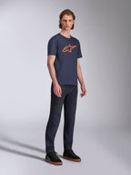 Alpinestars Ageless 2.0 CSF T-Shirt, Kurzarm-T-Shirt, Dunkelblau mit orangefarbenem Stern-Logo, kombiniert mit dunklen Denim-Jeans und schwarzen Sneakern, lässige, vom Motorsport inspirierte Streetwear