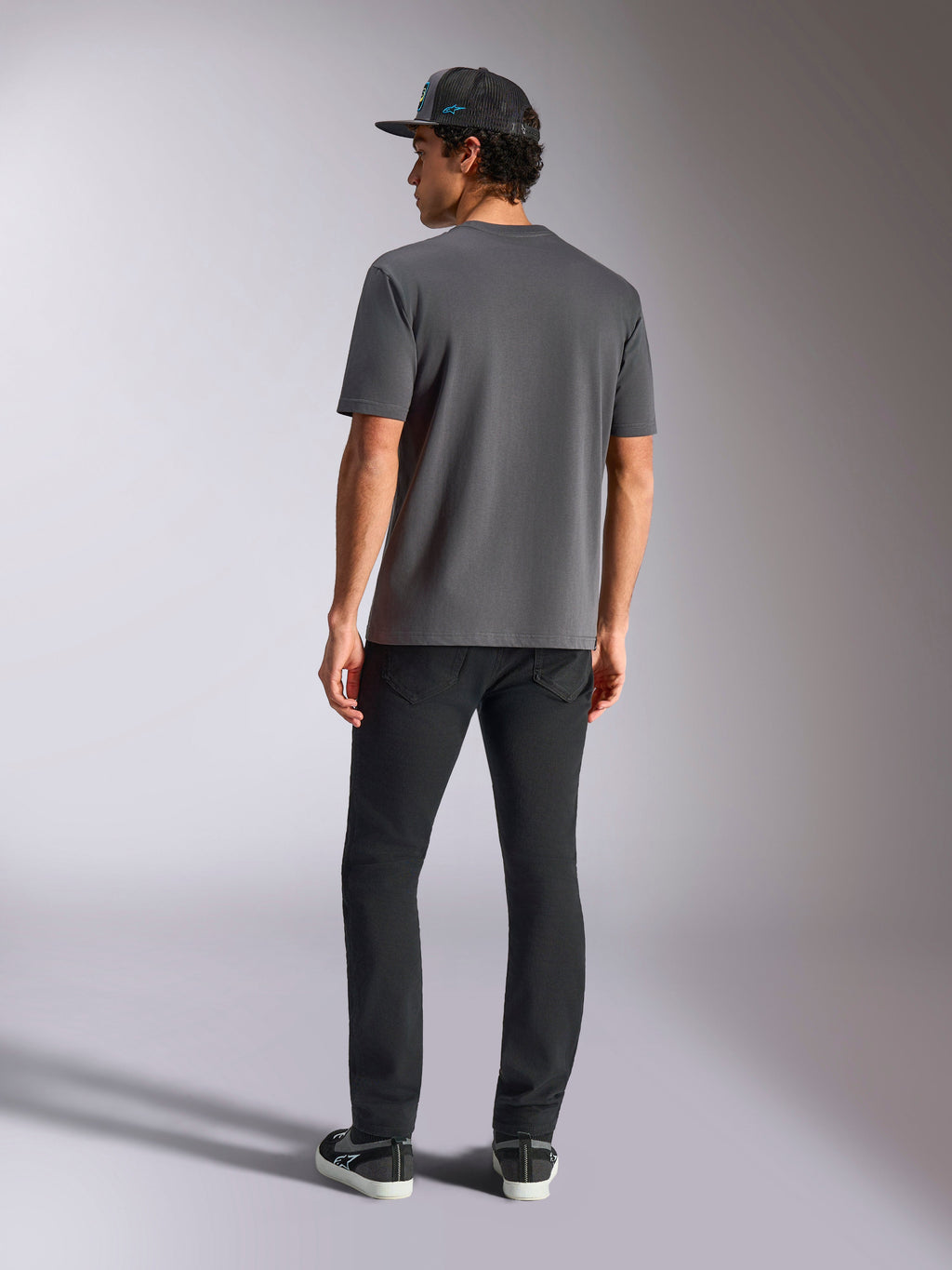 Alpinestars Blaze 2.0 CSF T-Shirt, Anthrazitgrau, Rückansicht, Kurzärmeliges T-Shirt, kombiniert mit schwarzer Hose und schwarzer Mesh-Kappe, lässige Motorsport-Streetwear