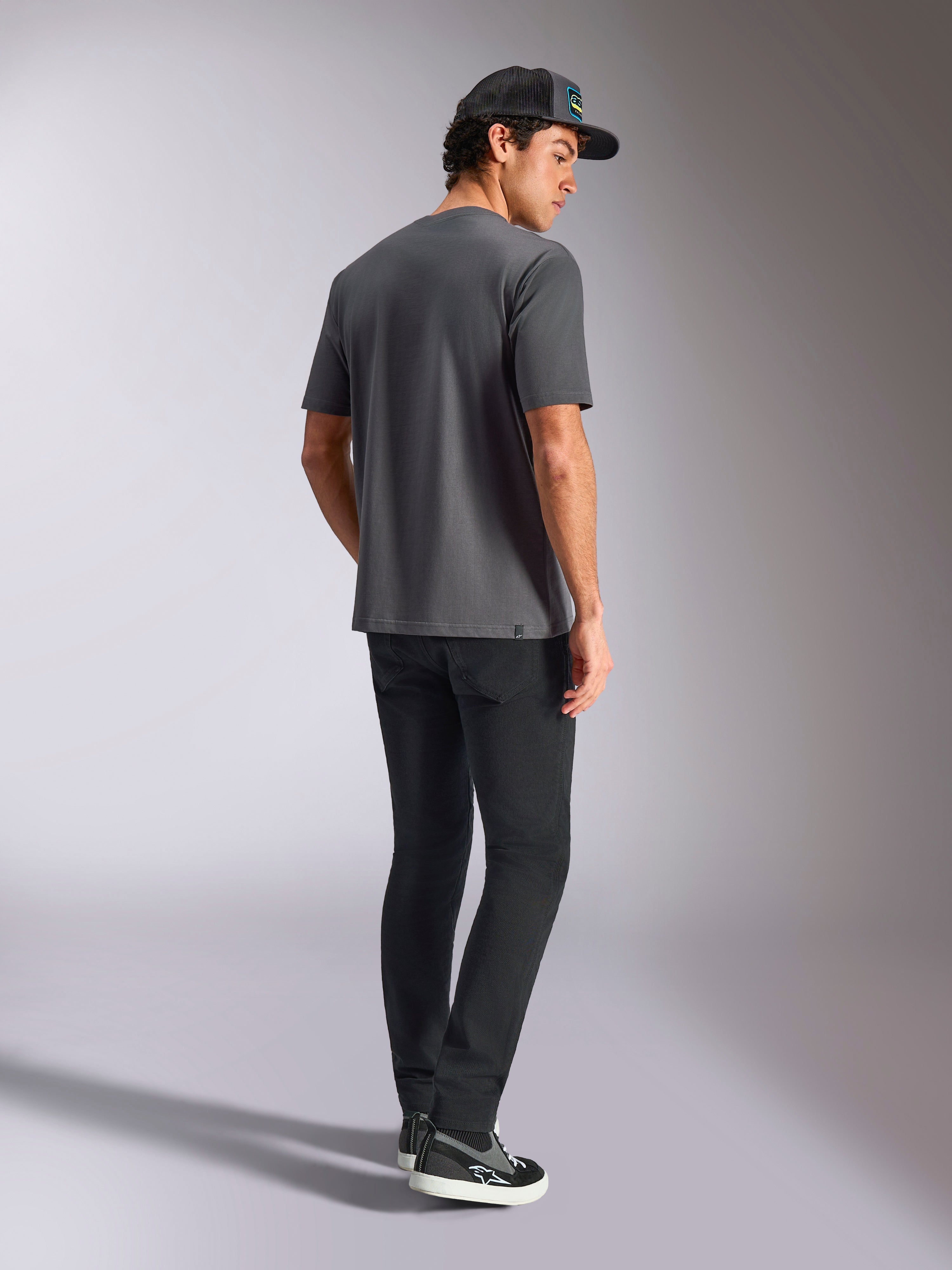 Alpinestars Blaze 2.0 CSF Tee, Kurzarm-T-Shirt, Grau, Rückansicht, getragen von einem Model mit schwarzer Hose und schwarzer Kappe, lässige Motorsport-Streetwear