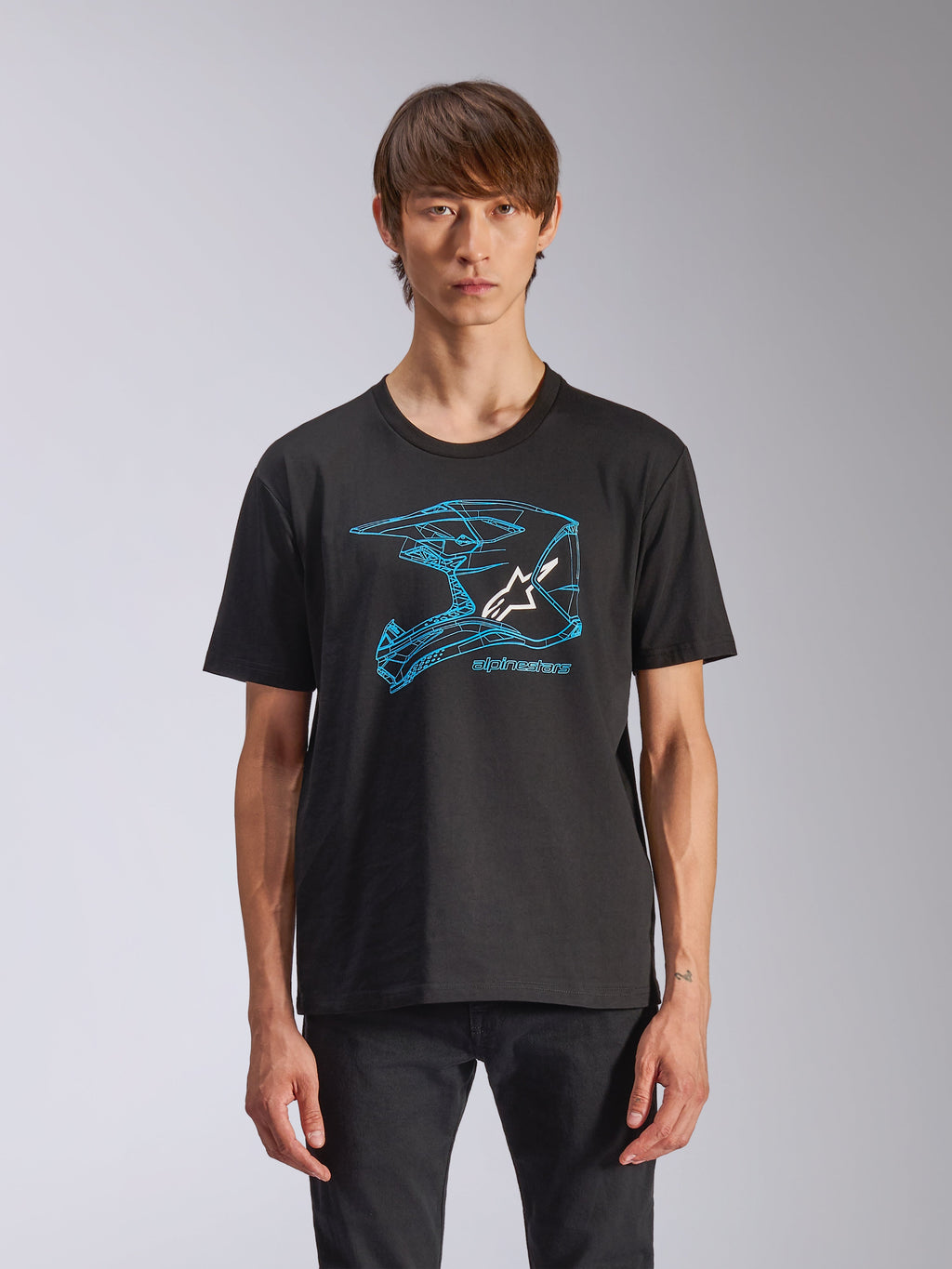 Alpinestars CSF Tee, kurzärmeliges T-Shirt, Schwarz, blaue Motocross-Helm-Grafik mit weißem Astars-Logo, lässige, vom Motorsport inspirierte Streetwear, getragen von einem Model