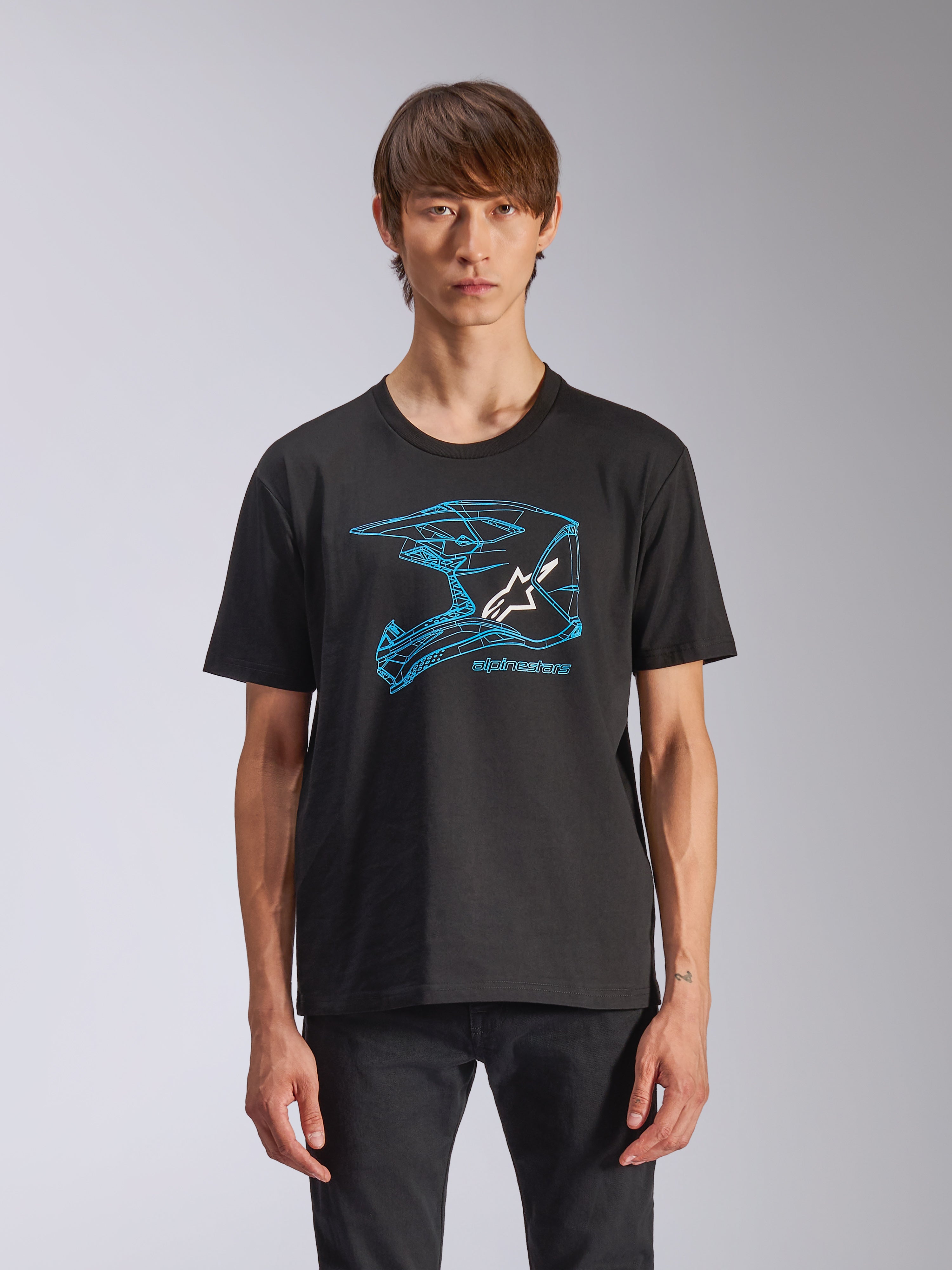 Alpinestars CSF Tee, kurzärmeliges T-Shirt, Schwarz, blaue Motocross-Helm-Grafik mit weißem Astars-Logo, lässige, vom Motorsport inspirierte Streetwear, getragen von einem Model