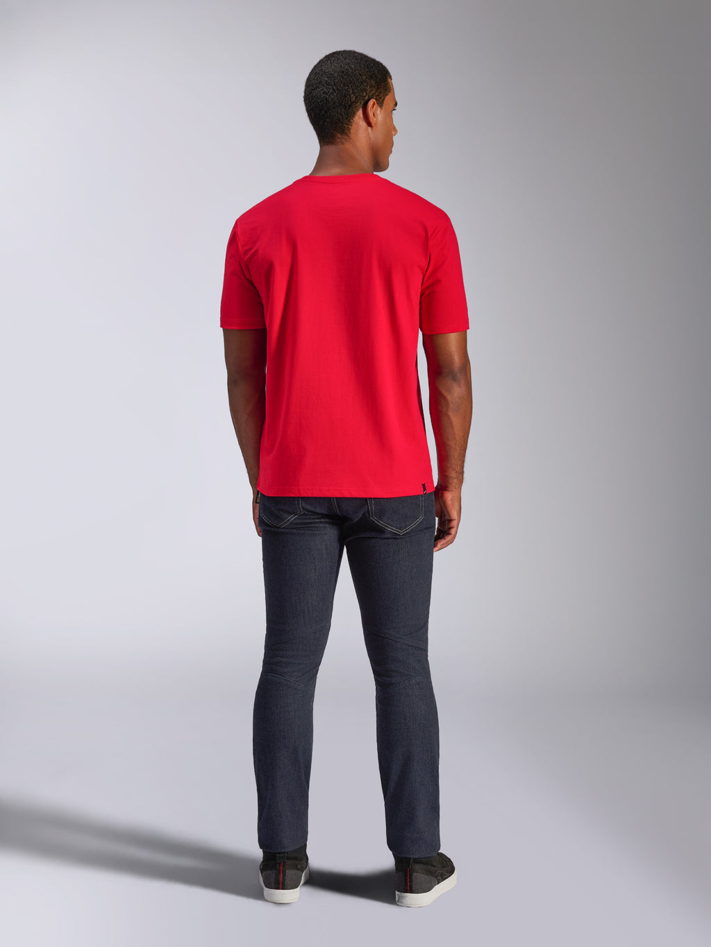 Alpinestars CSF Tee, Kurzarm-T-Shirt, Rot, Rückansicht am Modell, kombiniert mit dunkler Denim-Jeans, lässige Motorsport-inspirierte Streetwear