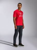 Alpinestars CSF Tee, Kurzarm-T-Shirt, Rot, Weiße MX-Helm-Grafik, getragen von einem Model mit dunklen Denim-Jeans und schwarzen Sneakern, Lässige Motorsport-Streetwear