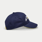 Alpinestars Par Hat, dunkelblaue Baseballkappe, Seitenansicht mit weißer und gelber Logo-Stickerei, gebogener Schirm mit gelbem Sandwich-Besatz, lässige strukturierte Kopfbedeckung