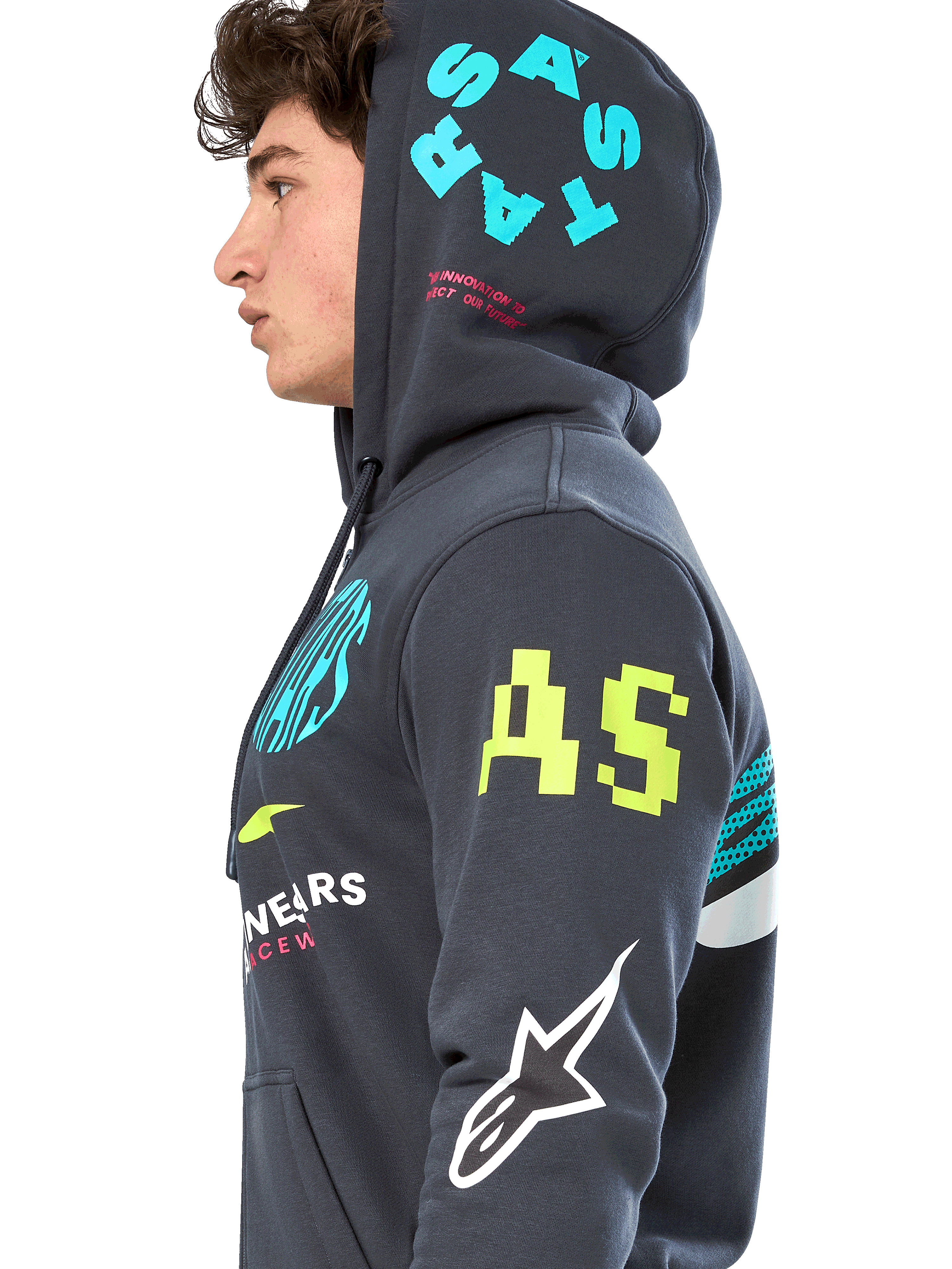 Alpinestars Variegate Hoodie, Fleece-Hoodie mit Reißverschluss in Gunmetal-Grau, Seitenansicht eines Models, Multi-Logo-Artwork in Neongelb, Hellblau und Weiß, mit 'AS'-Branding am Ärmel und 'STARS' auf der Kapuze, lässige Motorsport-inspirierte Streetwear