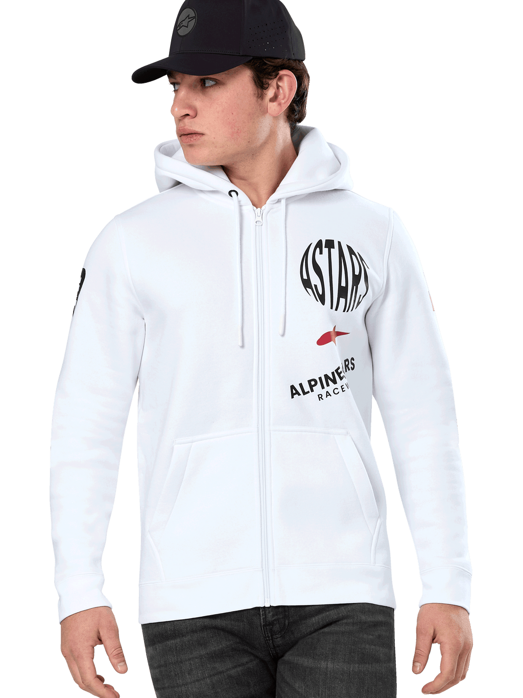 Alpinestars Variegate Hoodie, weißer Kapuzenpullover mit Reißverschluss, schwarze und rote ASTARS Racing-Grafiken, getragen von einem Model mit schwarzer Kappe und dunkler Jeans, lässige Motorsport-Streetwear mit Kängurutasche und Kapuze mit Kordelzug