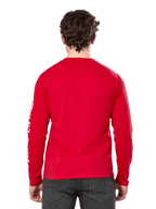 Rear view of a man wearing the Alpinestars Committed CSF Long Sleeve Tee in Red, paired with dark grey jeans, featuring a visible Alpinestars sleeve logo in white and a minimalist back design.