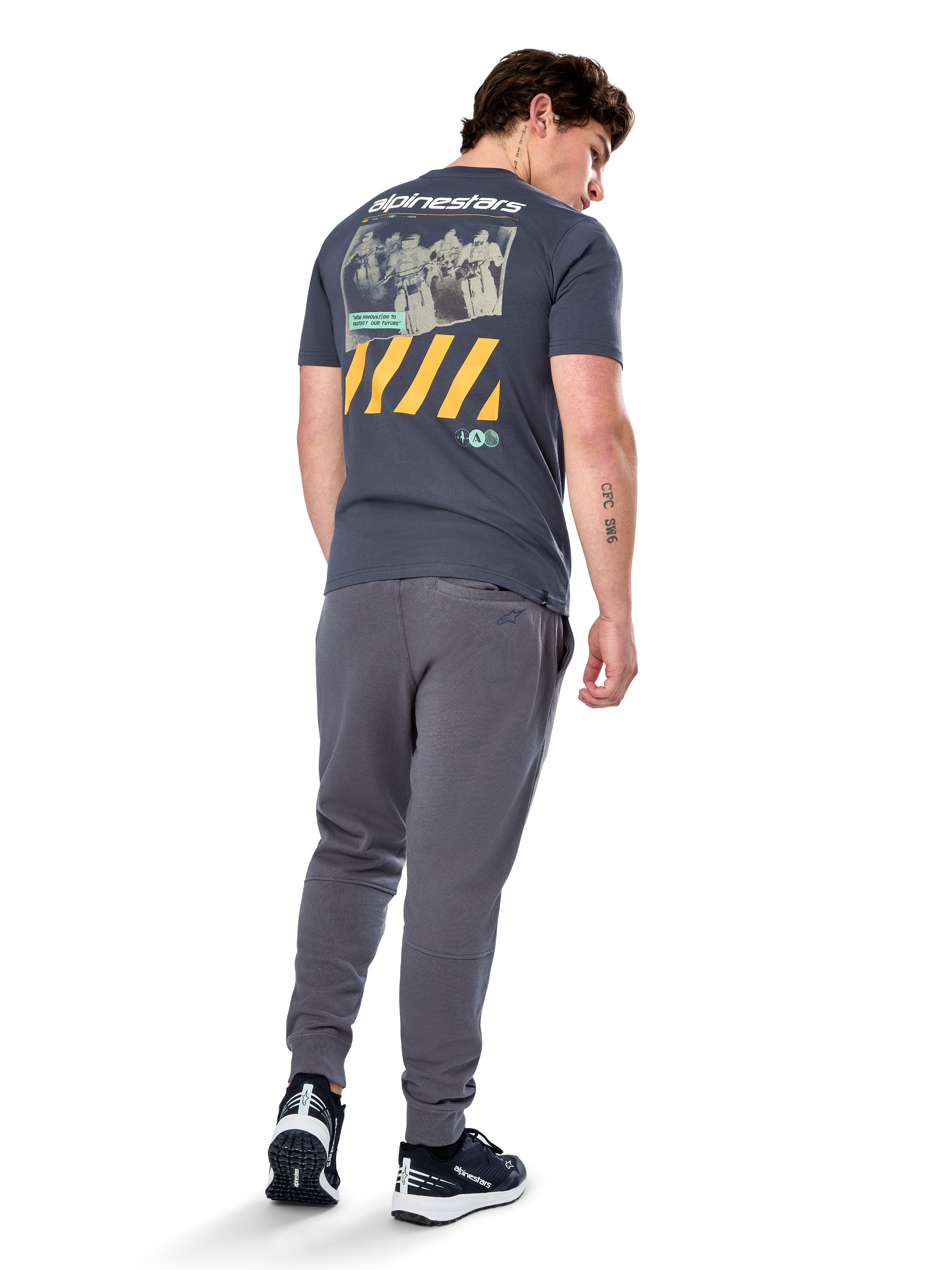 Alpinestars No Barrier CSF Tee, kurzärmeliges T-Shirt, Anthrazit, Rückansicht mit großer Distressed-Fotografik, gelben diagonalen Streifen und weißem Logo, lässige, vom Motorsport inspirierte Streetwear