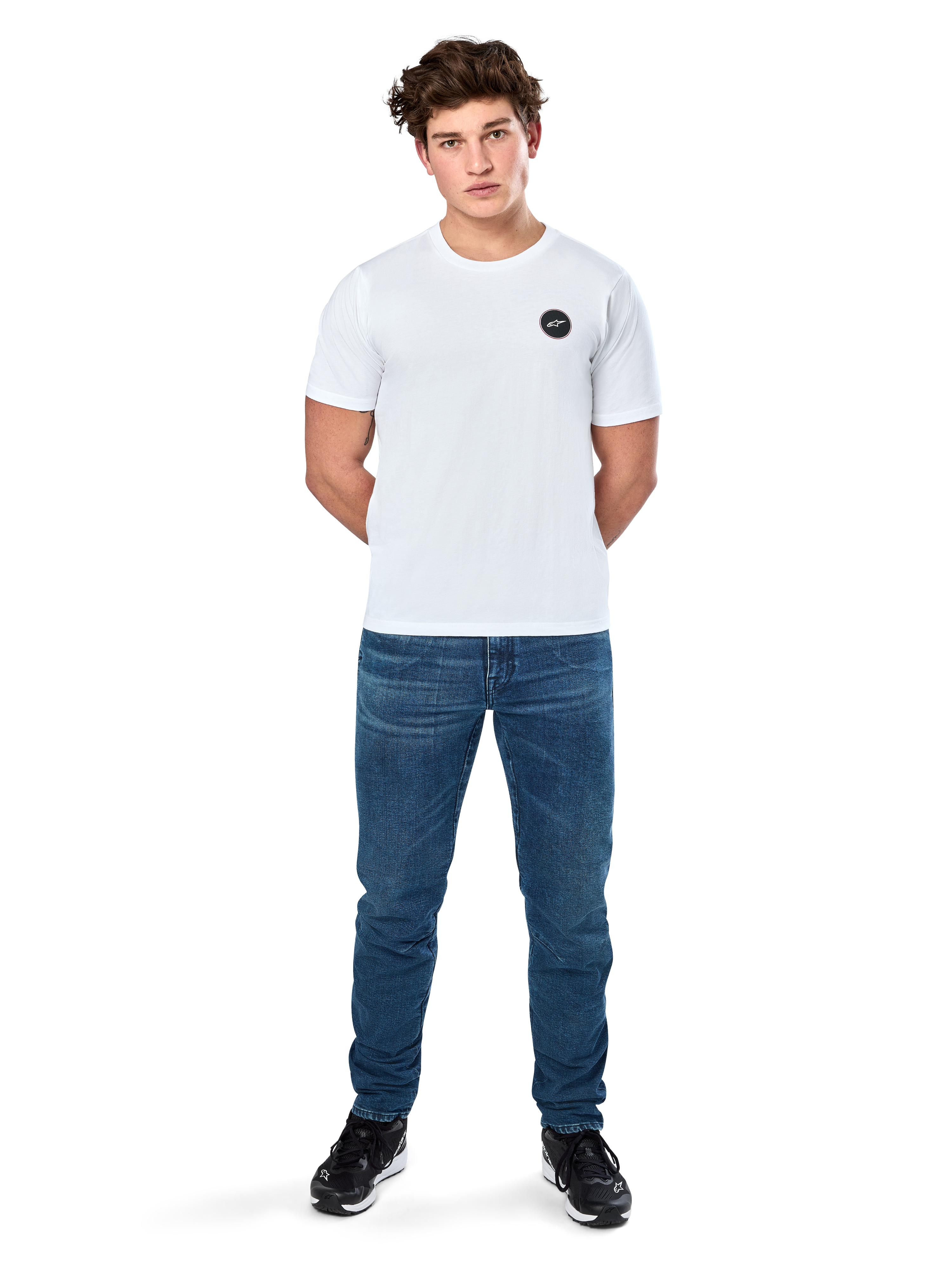 Alpinestars Dot Carbon Csf T-Shirt, Kurzarm-T-Shirt, Weiß, Rundes Astars-Logo in Carbonfaser-Optik, Lässige Motorsport-Streetwear, getragen von einem männlichen Model mit blauen Jeans und schwarzen Sneakern