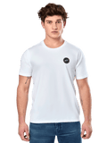 Alpinestars Dot Carbon CSF Tee, weißes Kurzarm-T-Shirt, männliches Model in weißem T-Shirt mit kleinem schwarzen kreisförmigen Logo auf der Brust und blauer Jeans, lässiger Motorsport-Stil