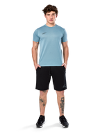 Alpinestars Point Performance Tee, Kurzarm-T-Shirt, Ice Blue, mit kleinem schwarzen Logo vorne, Rundhalsausschnitt, getragen von einem Model mit schwarzen Shorts und schwarzen Sneakern, lässige feuchtigkeitsableitende Sportbekleidung