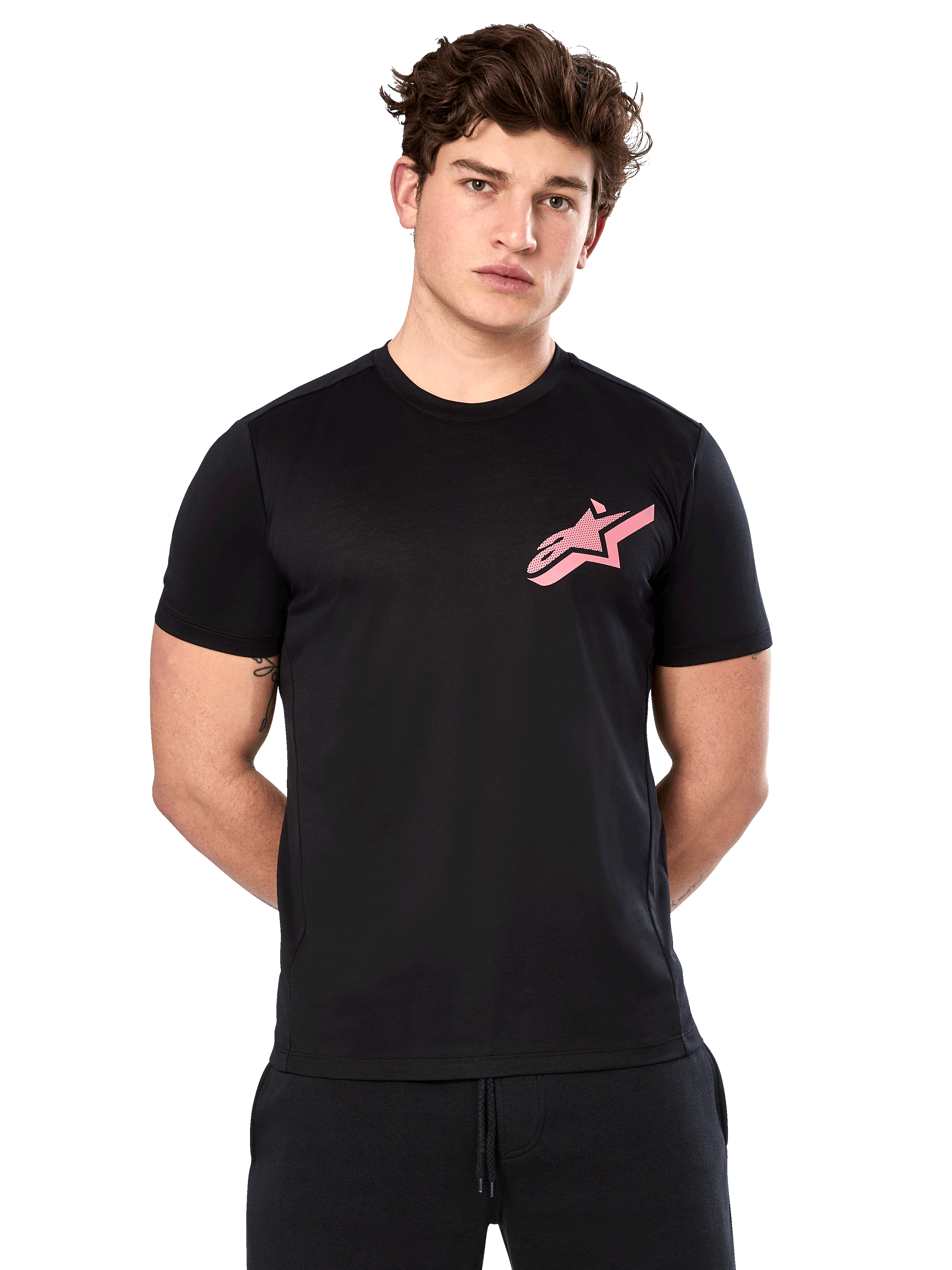 Alpinestars Attrition Performance Tee, kurzärmeliges T-Shirt, Schwarz mit rosa Astars-Logo auf der Brust, getragen von einem männlichen Model, lässige Motorsport-Performance-Bekleidung