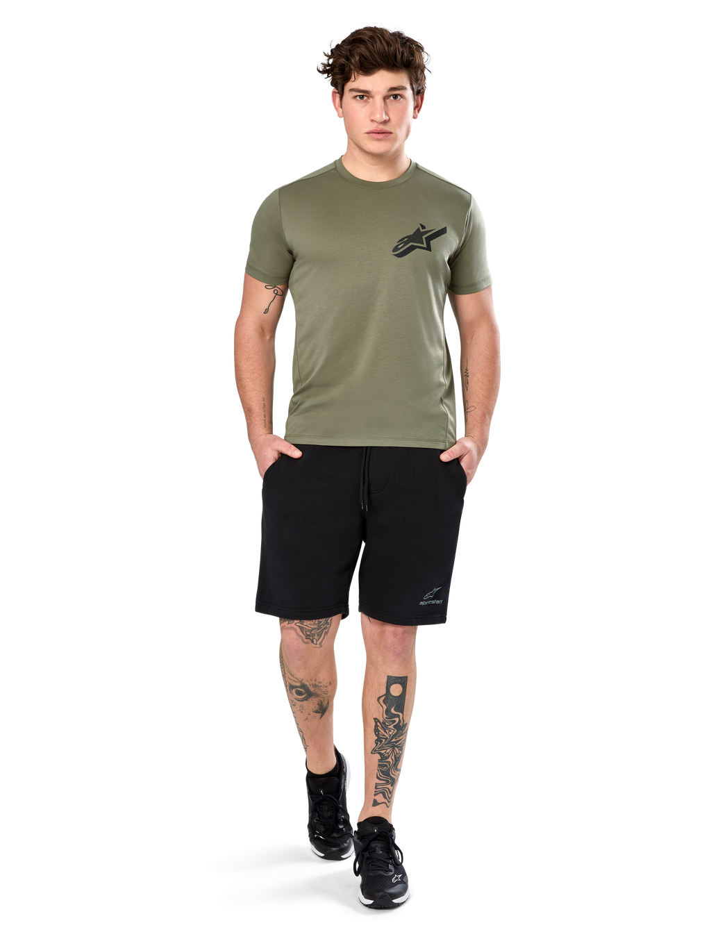 Alpinestars Attrition Performance Tee, Kurzarm-T-Shirt, Hellgrün, mit schwarzem Astars-Logo auf der Brust, getragen mit schwarzen Sport-Shorts und schwarzen Sneakern, Lifestyle-Aufnahme für funktionale Sportbekleidung