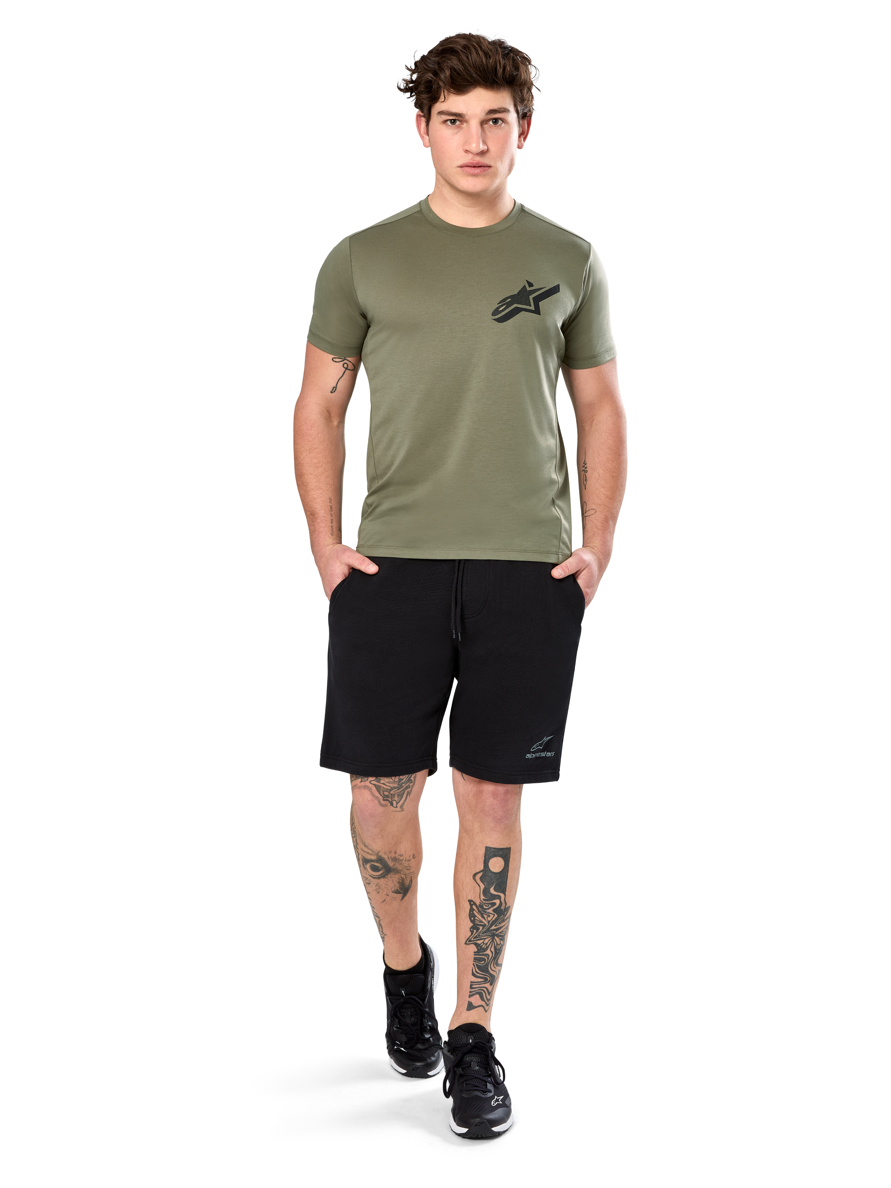Alpinestars Attrition Performance Tee, Kurzarm-T-Shirt, Hellgrün, mit schwarzem Astars-Logo auf der Brust, getragen mit schwarzen Sport-Shorts und schwarzen Sneakern, Lifestyle-Aufnahme für funktionale Sportbekleidung
