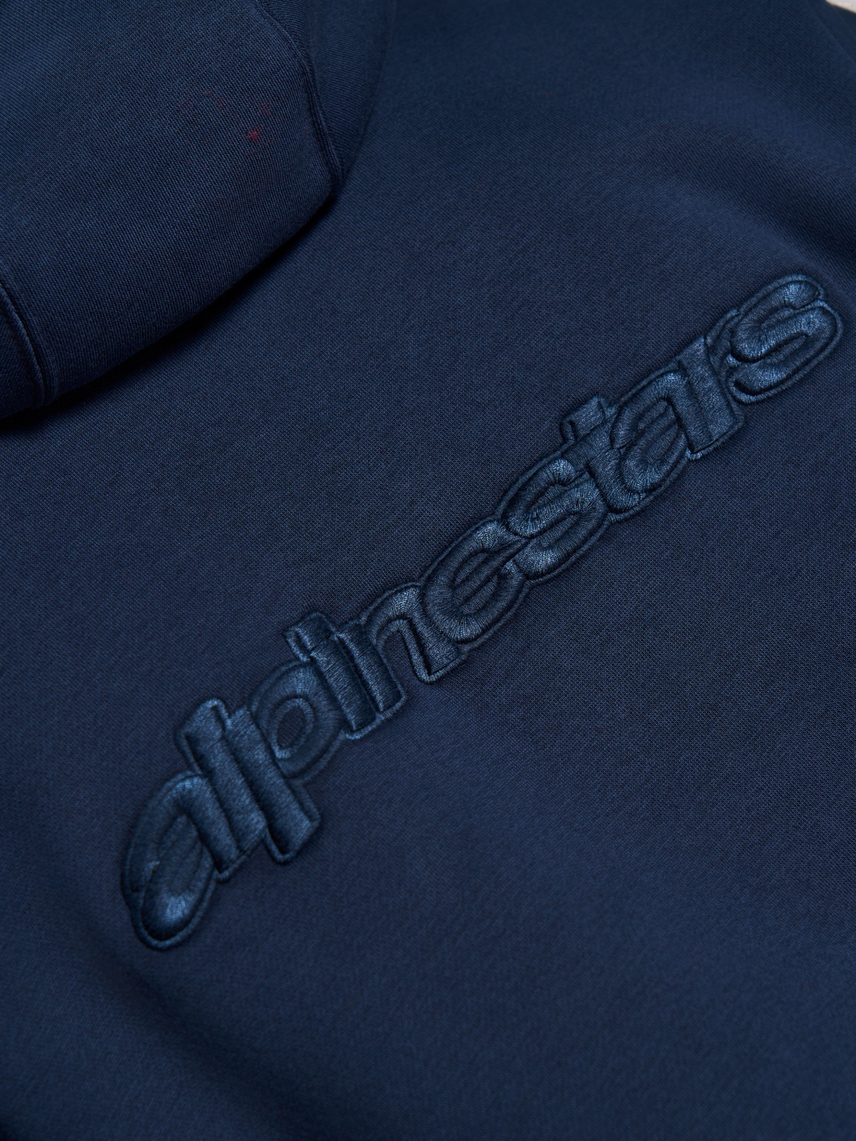 Alpinestars Emergent Oversized Hoodie, Navyblau, Nahaufnahme des tonalen 3D-gestickten Alpinestars-Wortlogos auf der Rückseite, hochwertige Fleece-Textur