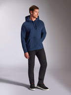 Alpinestars Emergent Oversized Hoodie, Marineblau, getragen von einem männlichen Model mit schwarzer Hose und Sneakern, mit 3D-gesticktem Astars-Logo, Kängurutasche und Kapuze mit Kordelzug, lässige, vom Motorsport inspirierte Streetwear.