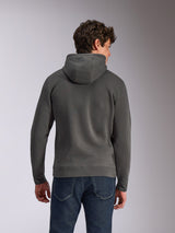 Alpinestars Ellipsoid Hoodie, Gunmetal-Grau, lässige Sportbekleidung, Rückansicht eines Mannes, der einen Fleece-Kapuzenpullover trägt, Rippbündchen an Saum und Ärmelabschlüssen, kombiniert mit blauen Jeans