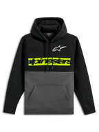 Alpinestars Parallel Hoodie, lässiger Fleece-Kapuzenpullover im Color-Block-Design, schwarzes Oberteil und Ärmel mit gunmetal-grauem Unterteil, weißes Astars-Logo auf der Brust, leuchtend gelb-grüner horizontaler Balken mit schwarzem Alpinestars-Wortlogo, Kapuze mit Kordelzug und Kängurutasche vorne